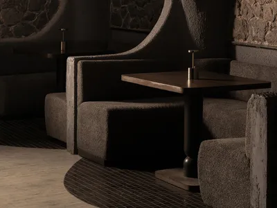 Inviting restaurant interior with stone walls, cement elements, and comfortable seating areas