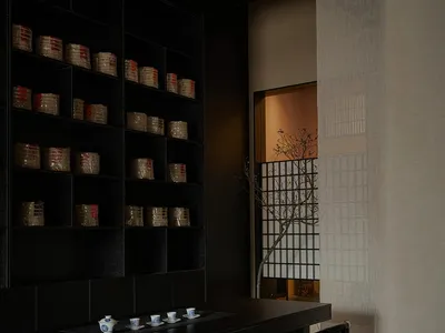 簡約亞洲風格餐廳空間，配有黑色餐桌、兩把椅子與溫馨氛圍