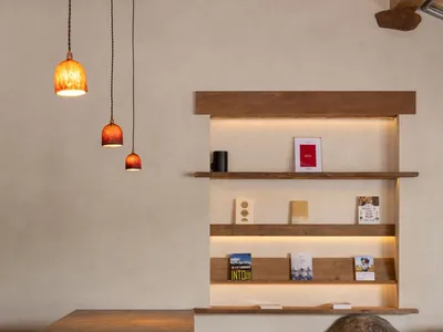A cozy living space with a wooden bookshelf and dining table, featuring a visually appealing book arrangement and inviting atmosphere
