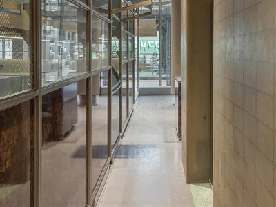 光線充足的玻璃牆餐廳走廊，木質地板與座椅