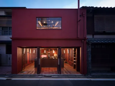 Inviting restaurant interior with a red exterior wall, dining tables, chairs, and cups, providing a comfortable dining experience