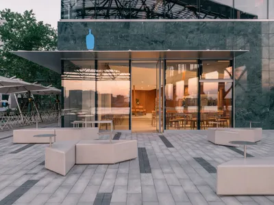 Inviting social space with seating areas, dining tables, and potted plants, featuring a warm and comfortable atmosphere