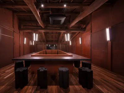 木飾面板的餐廳與酒吧區，搭配餐桌、椅凳與燈具，營造溫暖親切的氛圍