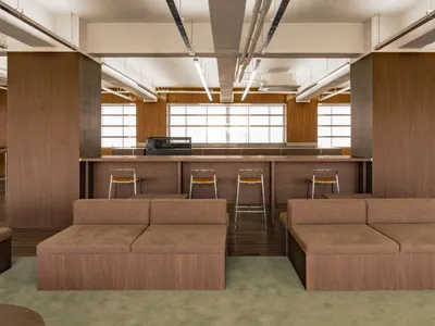 Cozy open concept living space with a brown couch, bar counter, and additional seating options
