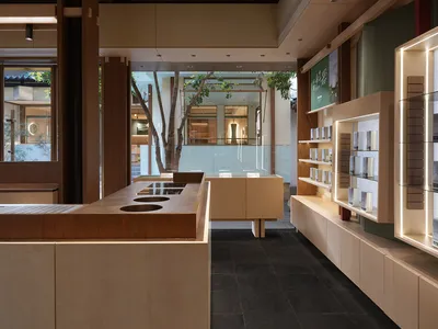 Warm and inviting store interior with wooden floors and walls, natural light, and seating areas