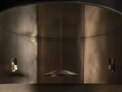 Dining room with a black and gold color scheme, featuring a dining table and chairs, two couches, and metallic elements