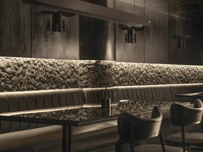 Modern restaurant bar with black leather chairs and tables, surrounded by a stylish and sophisticated atmosphere