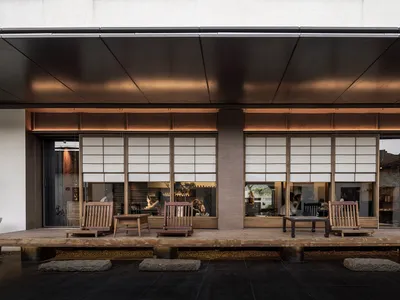 Asian restaurant with wooden furniture and a patio area, featuring sliding doors and a warm, inviting atmosphere