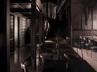 A dark and moody restaurant with black and white decor, featuring multiple tables and chairs, creating a unique ambiance