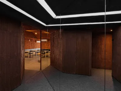 A warm and inviting room with wooden walls and floors, featuring a dining table and chairs, creating a cozy atmosphere