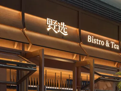 溫暖親切的酒館內部，木質牆面與地板，配有餐桌椅以及桌上的各式瓶裝飲品