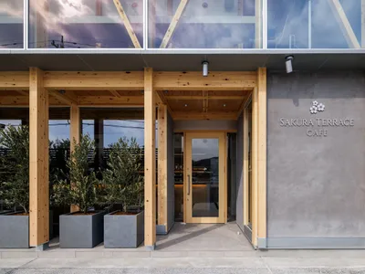 Inviting restaurant entrance with a wooden doorway, potted plants, and a modern design