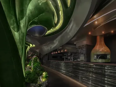 Modern restaurant bar with black marble walls, potted plants, and a countertop