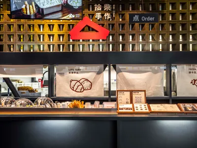 A modern restaurant with a black countertop, red triangle symbol, and various food items on display