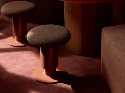 A warm and inviting living area with a wooden table surrounded by leather-covered stools