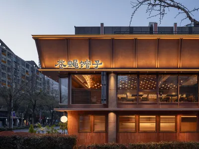 Cozy Asian restaurant with a wooden exterior, stone accents, and a warm atmosphere, featuring dining tables and natural light