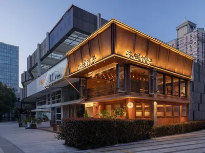 A modern Asian restaurant with a large wooden structure and glass elements, set against a well-lit interior with a warm and inviting atmosphere