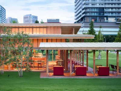 一座溫馨的戶外餐廳，設有木構建築、紅色屋頂，以及多張餐桌椅