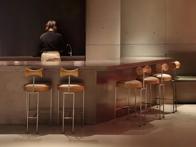 Modern restaurant interior with a counter and two chairs, providing seating options for customers