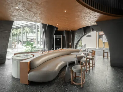 Modern restaurant interior with a bar area, wooden accents, and natural light from windows