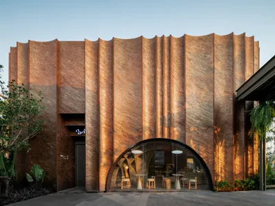 Inviting restaurant with an arched entrance, multiple dining tables, and comfortable seating