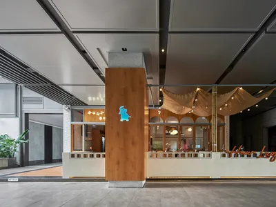 溫暖親切的餐廳內部，設有木質酒吧與多張餐桌，營造舒適氛圍並融入木質元素