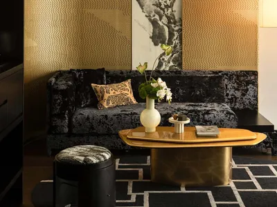 Cozy living area with a couch, a large painting on the wall, and decorative vases on a table