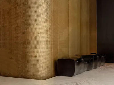 Modern living room with gold wallpaper, two couches, a chair, and a sophisticated atmosphere