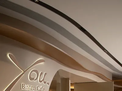 Spacious bistro cafe with brown and white walls, potted plants, and a modern atmosphere