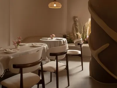 A dining area with a long table and multiple chairs, set with various items, creating an inviting atmosphere for guests