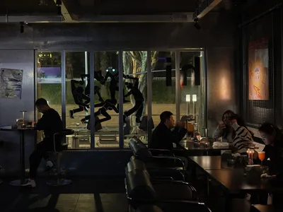 A modern dining area with metal tables and chairs, black and grey tones, and a relaxed atmosphere