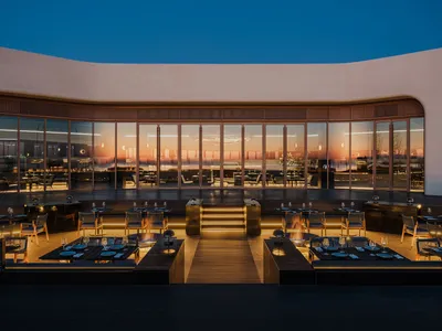 Elegant dining space with multiple tables, chairs, and wine glasses, creating a comfortable environment for social gatherings