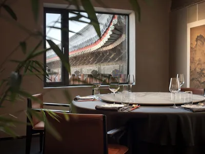 Sophisticated dining space with round tables, wine glasses, utensils, and comfortable seating
