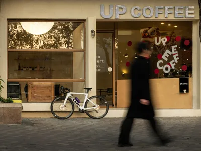 A casual coffee shop with comfortable seating, bicycles parked outside, and a welcoming atmosphere