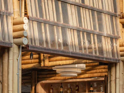 Warm and inviting Asian restaurant bar with a wooden shelf, wine glasses, and bamboo elements