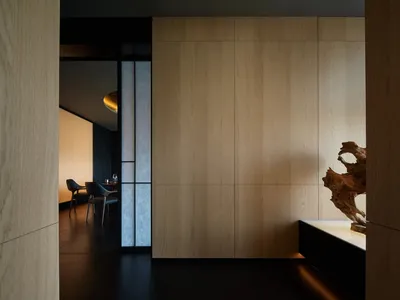 Warm and inviting interior space with wooden walls and floors, featuring a dining table and two chairs