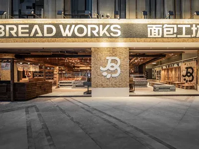 Warm and inviting store interior with a brick wall, wooden floor, and several chairs placed throughout the space