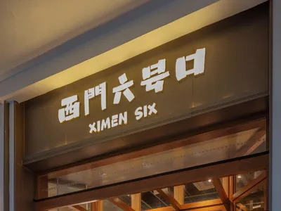 An inviting Asian restaurant with wooden walls, a large sign, and chairs and bottles on display
