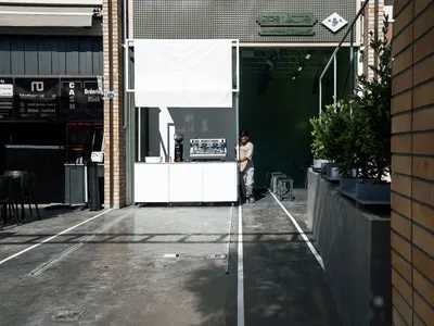 A casual commercial space with a white counter, chairs, and cups, creating a welcoming atmosphere for patrons