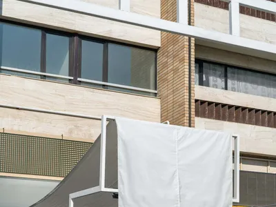 An outdoor cafe with white canopies, tables, and chairs, featuring a casual atmosphere and lively public space