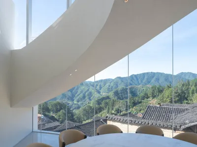 擁有大型窗戶提供全景視野的餐廳，木質椅凳與餐桌