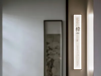 亞洲風格客廳區，白色牆面、東方畫作、燈具與花瓶，營造文化豐富氛圍