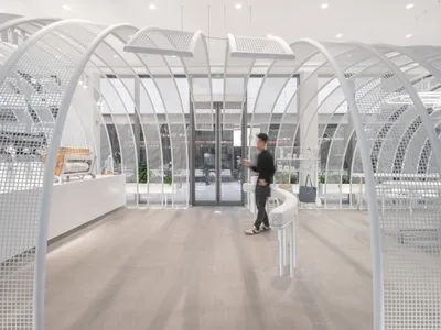 明亮溫馨的現代商店與餐廳，擁有大型白色圓頂天花板、散置家具與盆栽植物