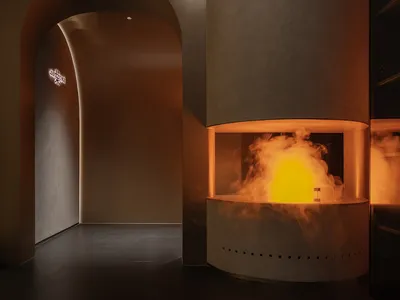 Cozy room with a stone fireplace, smoke billowing out, and a warm atmosphere