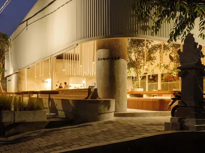 Open restaurant interior with multiple tables, white walls, and comfortable seating for guests