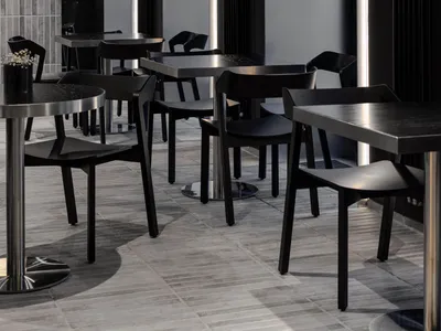 Sophisticated restaurant interior with black tables and chairs, multiple dining tables, and a modern atmosphere