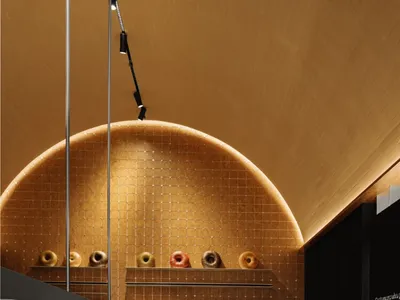 A colorful display of assorted donuts on a shelf in a well-lit showroom