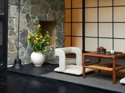 Cozy living space with a wooden table, chairs, a couch, and a fireplace, featuring a potted plant and warm atmosphere