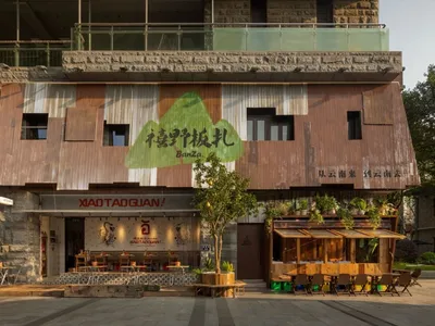 A restaurant with a dining area, tables, chairs, and potted plants, creating an inviting and comfortable atmosphere