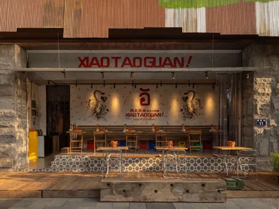 A restaurant with a blend of traditional and modern styles, featuring wooden walls, metal accents, and comfortable seating for guests